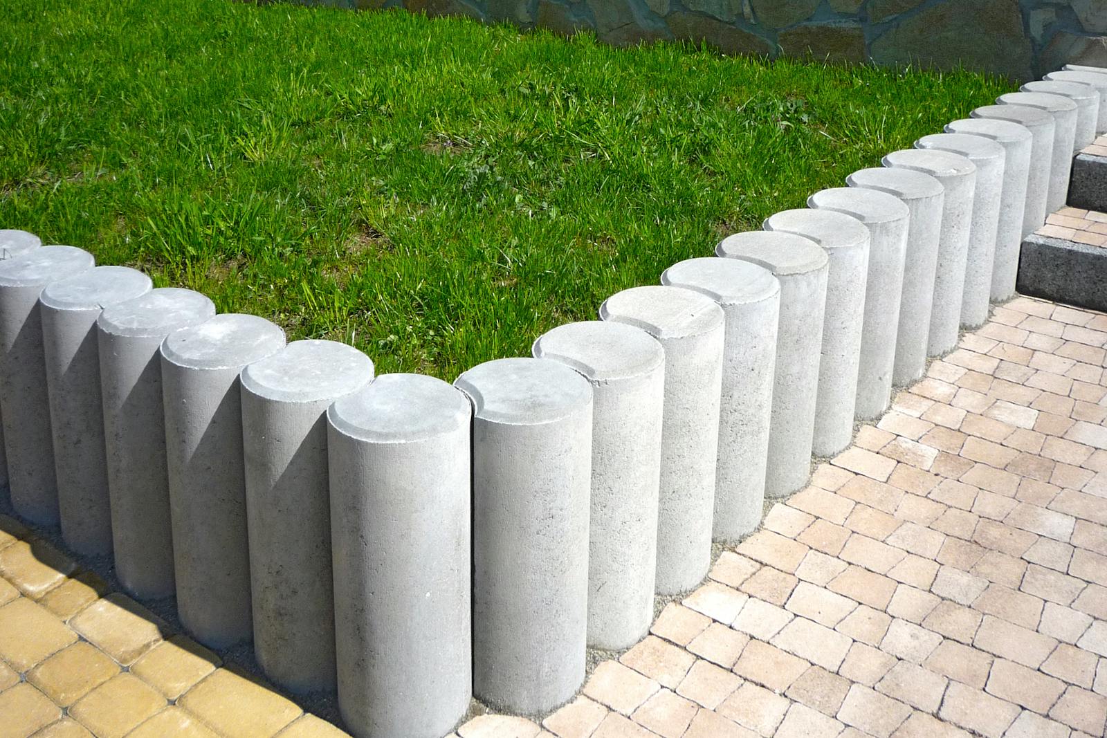 Sharp concrete edge separating a green Bermuda lawn from a decomposed-granite drive.