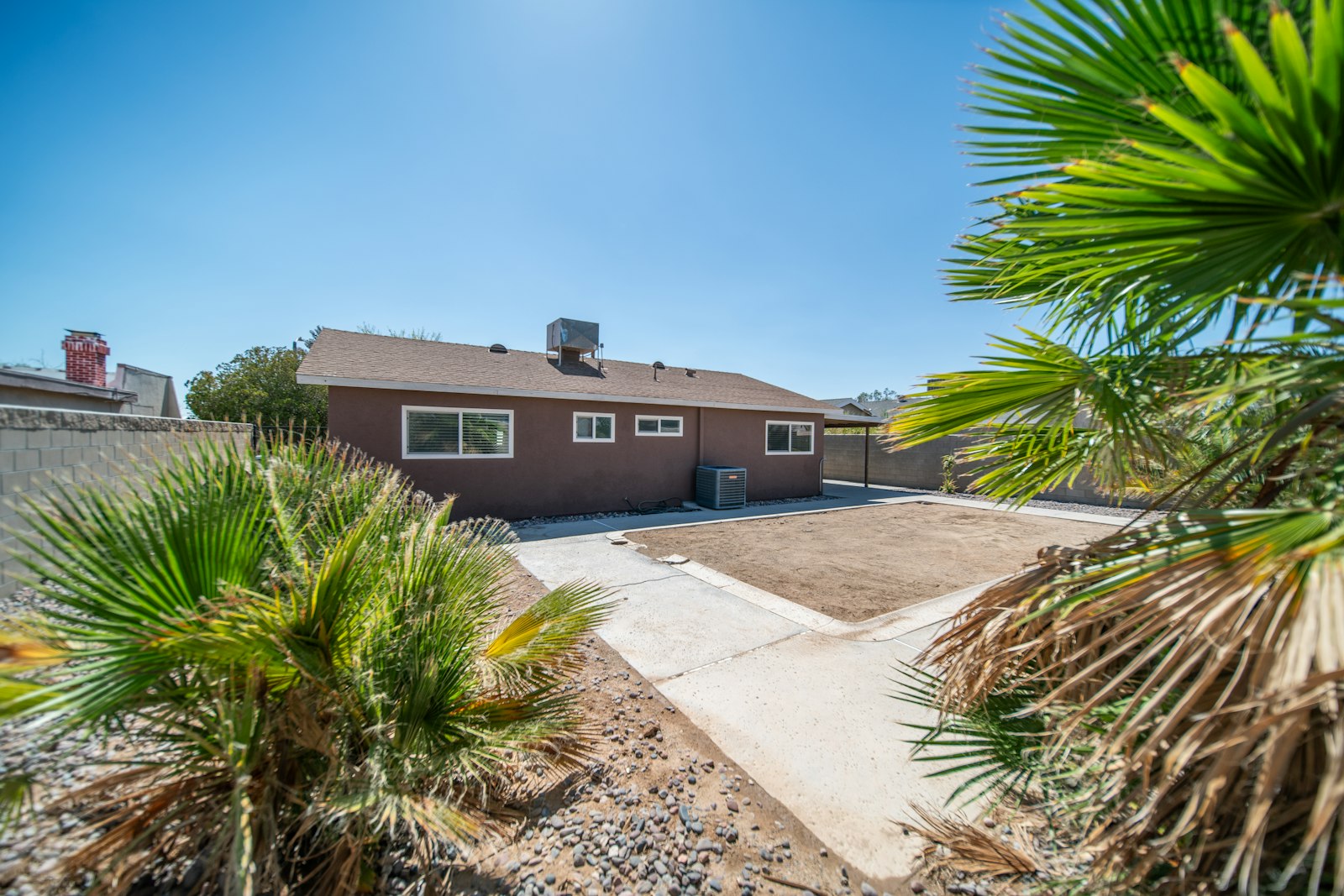 Front elevation of a Scottsdale home with a single mature palm and trimmed lawn.